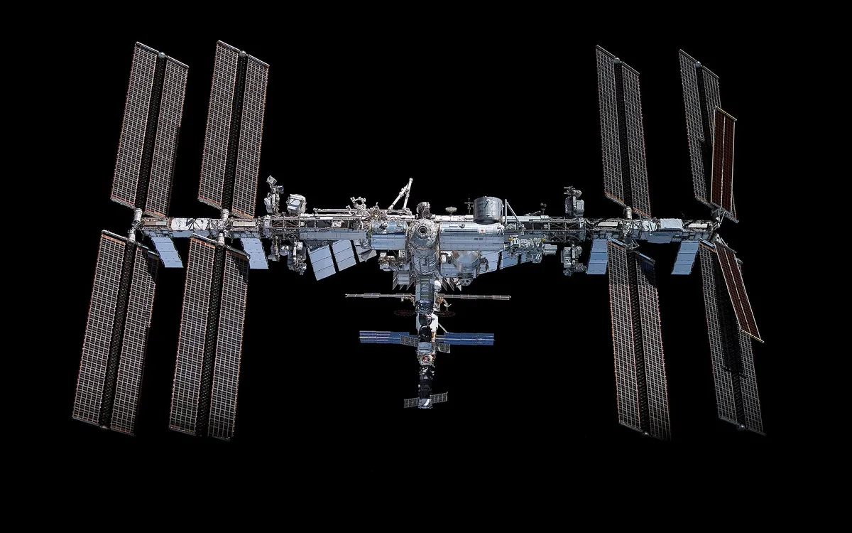 The International Space Station photographed against black space, solar arrays extended
