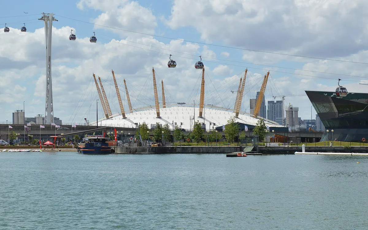 The domed roof and yellow masts of the O2 on the Greenwich Peninsula, seen across the Thames