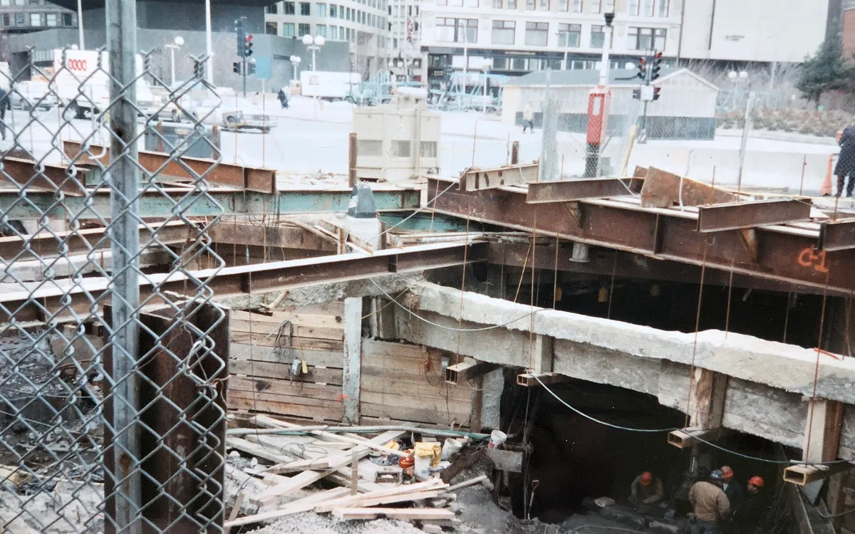 An open Big Dig excavation in downtown Boston, with shoring, steel decking and workers below street level